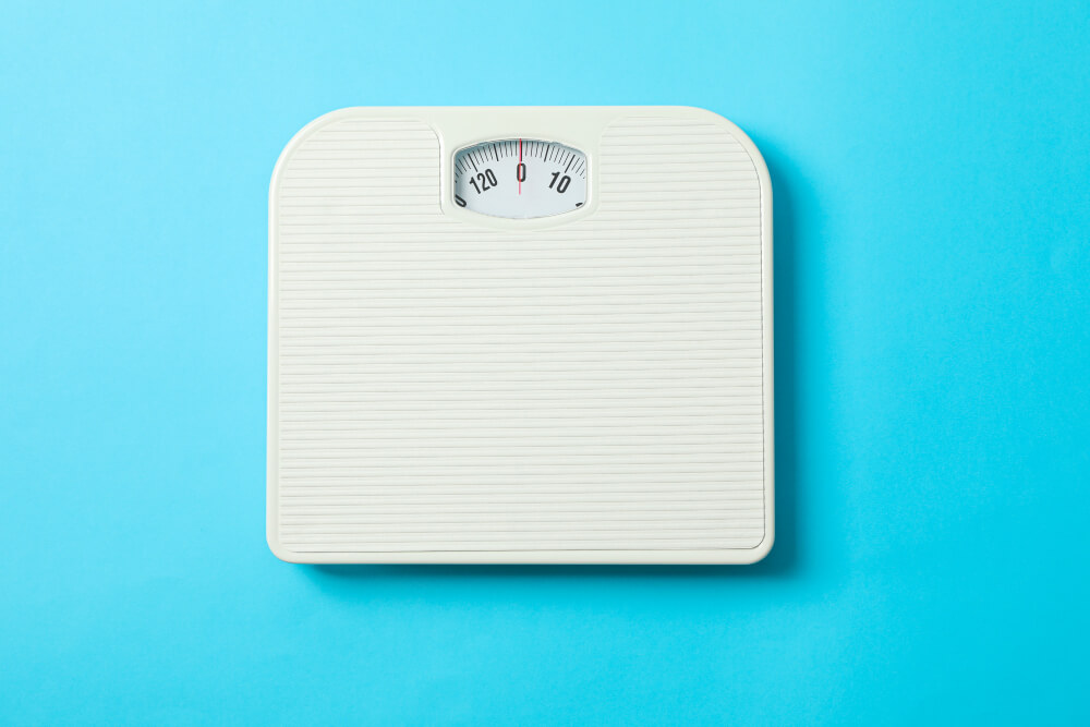 white-weigh-scales-blue-background-top-view